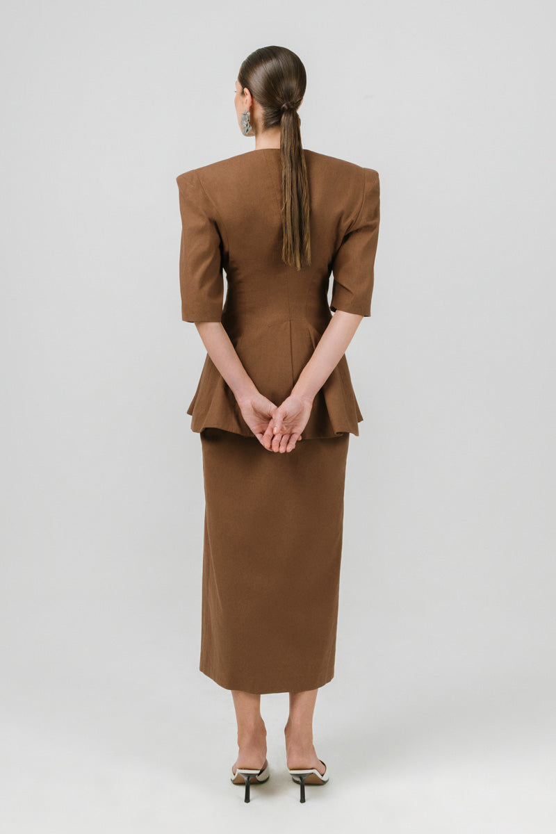 Brown Izakova Neda midi skirt with a flowy silhouette, displayed on a hanger against a neutral background.