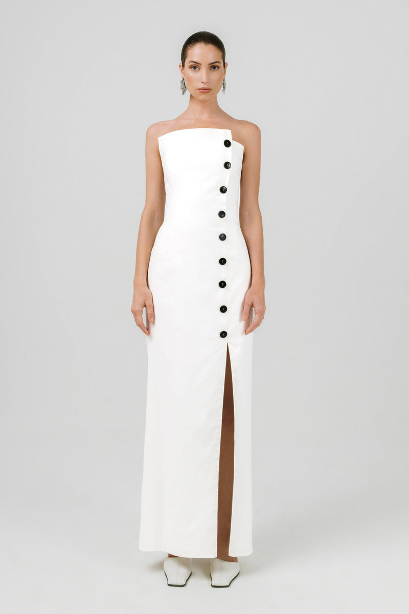 Elegant off-white Izakova Dariana maxi dress displayed on a hanger, showcasing flowing fabric and stylish design.