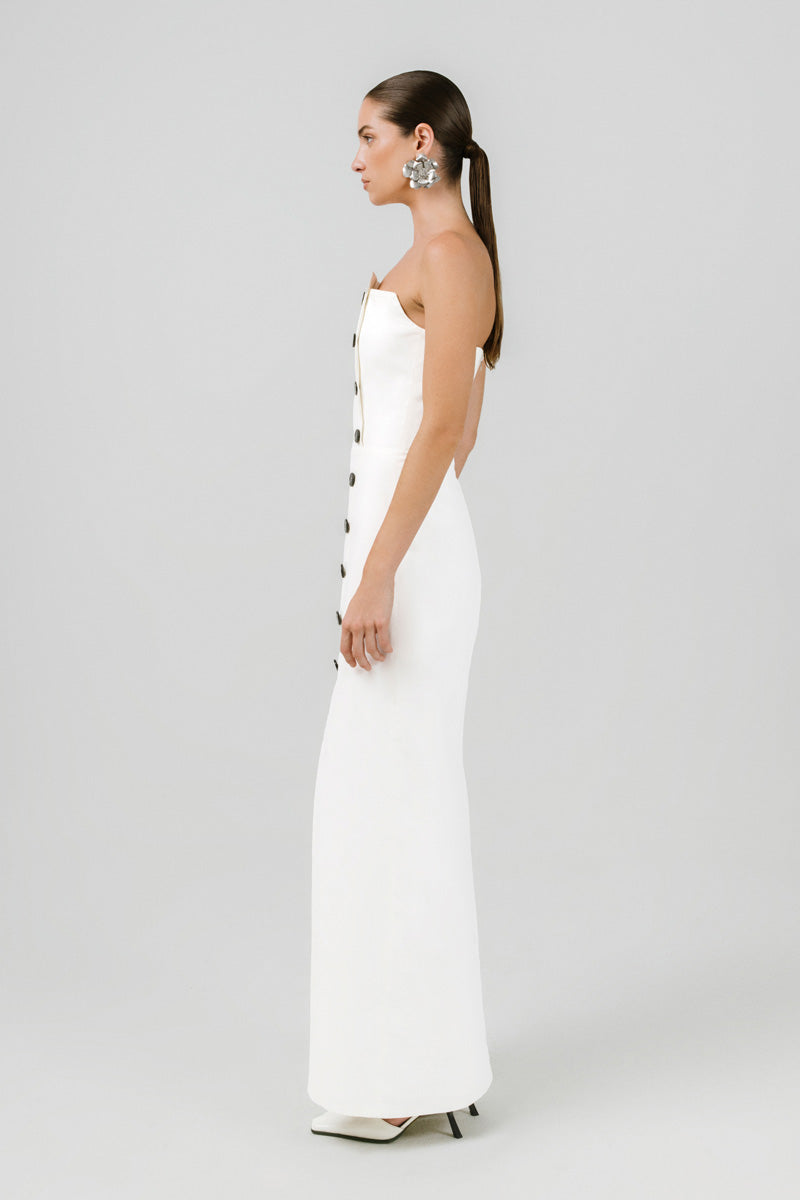 Off-white Izakova Dariana maxi dress displayed on a hanger, featuring flowing fabric and elegant design.