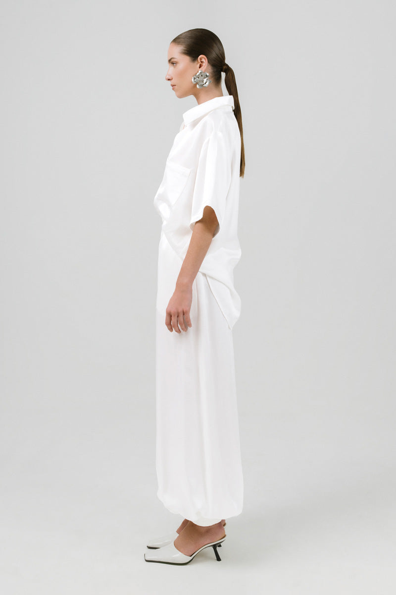 Izakova MAREA pants in a stylish, relaxed fit with a neutral color, showcased on a model standing outdoors.