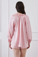 Pink loungewear set featuring a ruffle-trim blouse and matching shorts by MANITO, displayed on a neutral background.