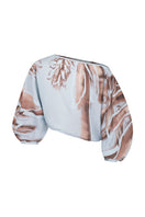Tinta Latina Jacinta blouse in blue print, featuring long sleeves and a relaxed fit, displayed on a hanger.