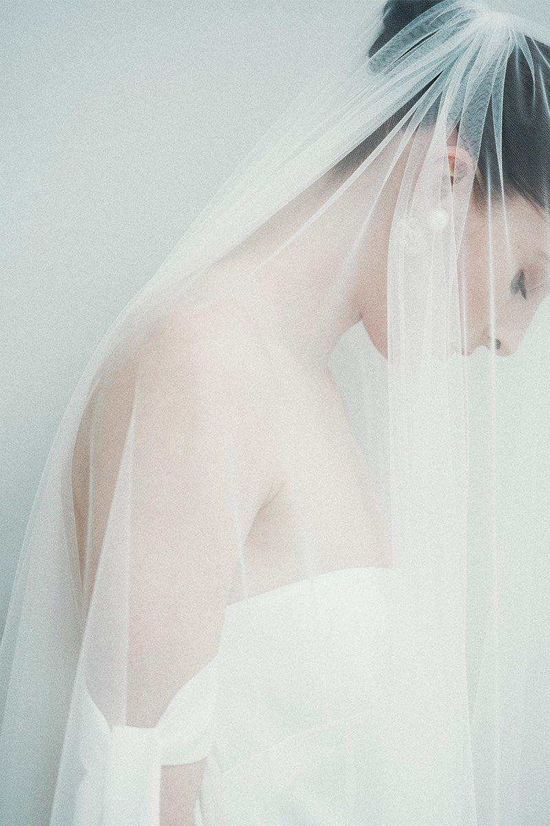 Elegant bridal long veil by JC Pajares featuring delicate lace trim, perfect for wedding hair accessories.
