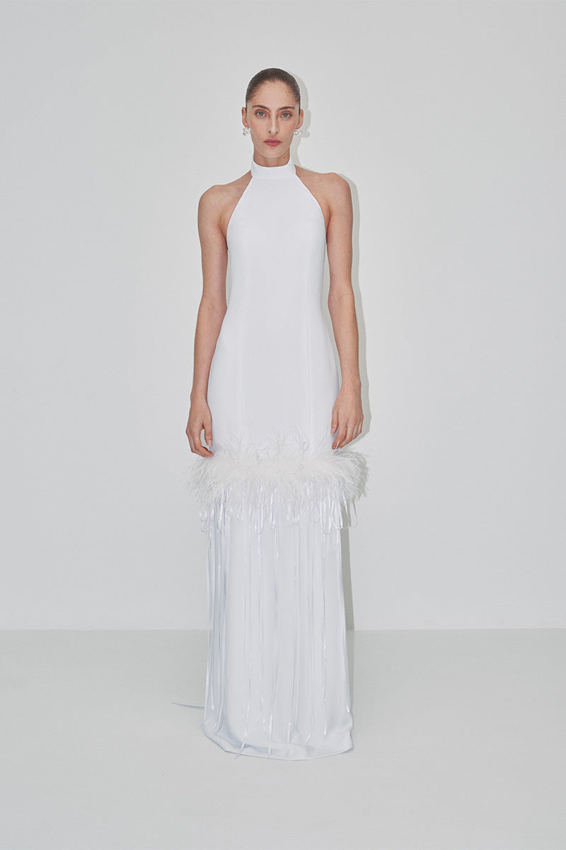 Elegant maxi dress with halter-neck and feather details by JC Pajares, shown in a bridal-inspired look.