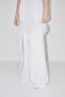 Elegant JC Pajares halter-neck maxi dress with feather details, perfect for bridal or special occasions, shown in a stylish lookbook image.