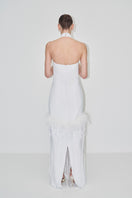 Elegant maxi dress with halter-neck and feather details from JC Pajares, showcased in a bridal-inspired lookbook image.