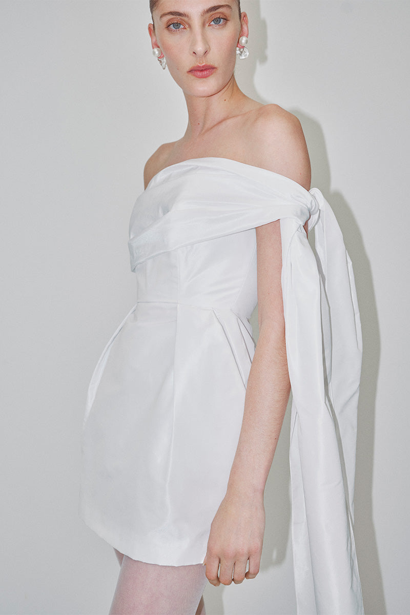 White tulip dress in double taffeta by JC Pajares, elegant mini dress with a fitted bodice and flowing skirt, bridal-inspired style.