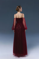 Elegant burgundy Rosalie gown by JOSÉPHINE, featuring a flowing design and detailed fabric texture.