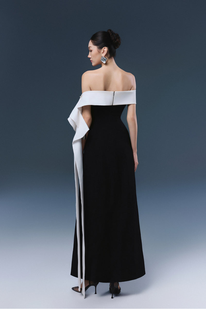 Black Magnolia maxi dress by JOSÉPHINE, shown hanging with flowing fabric and elegant design.