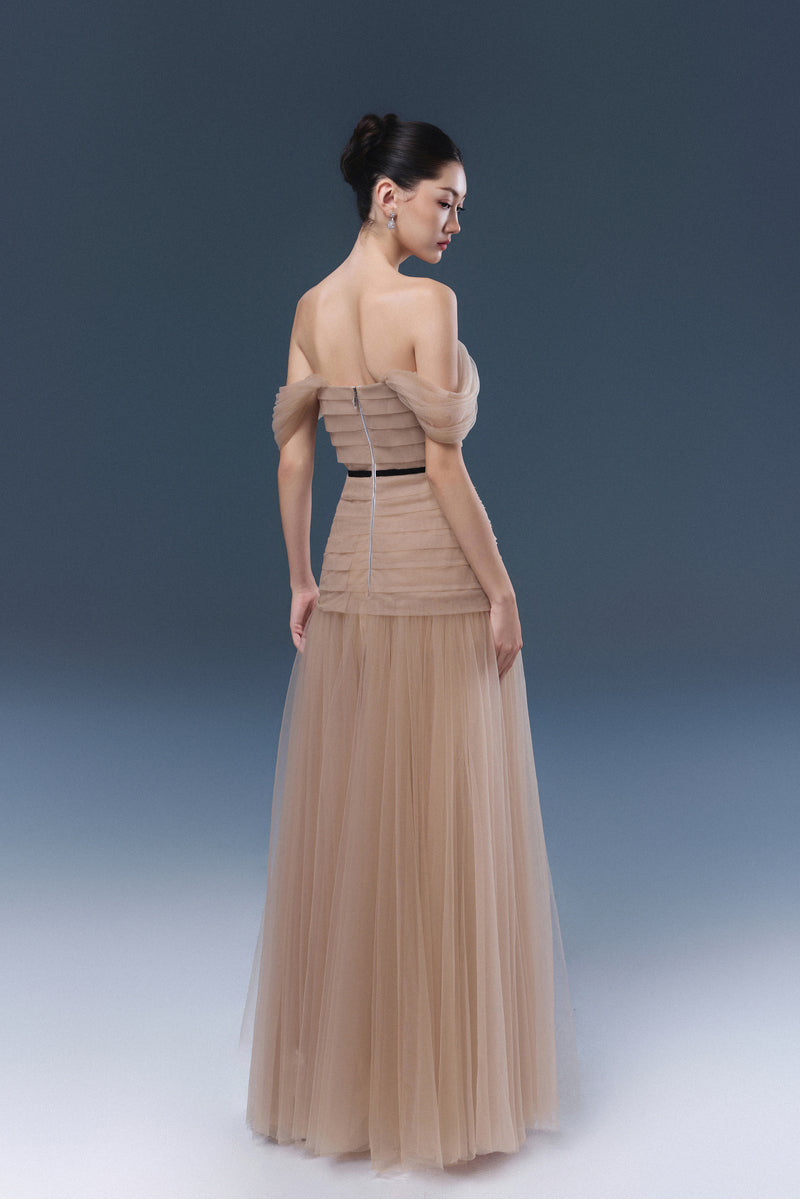 Beige ABIGAL maxi dress by JOSÉPHINE displayed on a hanger with flowing fabric and elegant design.