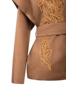 Ecru belted jacket by Nadya Shah featuring a relaxed fit and side details, styled as a versatile women's outerwear piece.