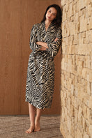Woman wearing a luxurious silk robe with a jungle zebra print by MANITO, featuring a stylish and elegant zebra pattern.