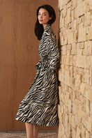 Woman wearing a luxurious silk robe with jungle zebra print by MANITO, featuring a flowing design and vibrant zebra pattern.
