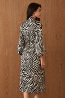 Woman wearing a luxurious silk robe with jungle zebra print by MANITO, showcasing the vibrant zebra pattern and elegant design.