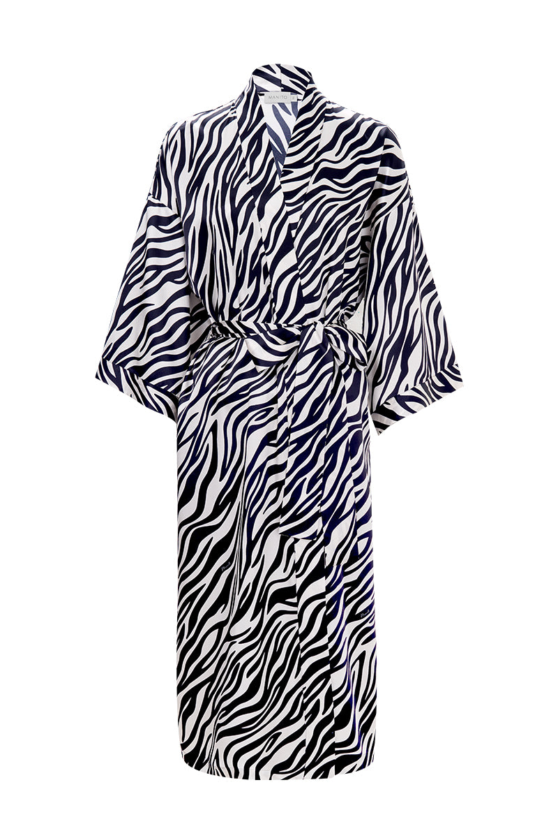Woman wearing a MANITO jungle zebra print silk robe, featuring a stylish zebra pattern and luxurious silky fabric.