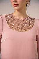Light pink Eira crepe gown by 21Six, featuring a flowing silhouette and elegant design, displayed on a hanger.