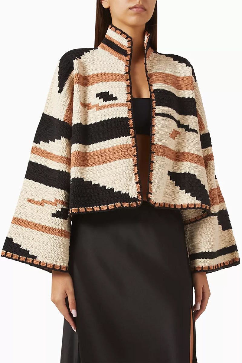 Jessica K KIONA cardigan in camel and black, soft knit fabric, displayed on a hanger with a close-up of the textured material.