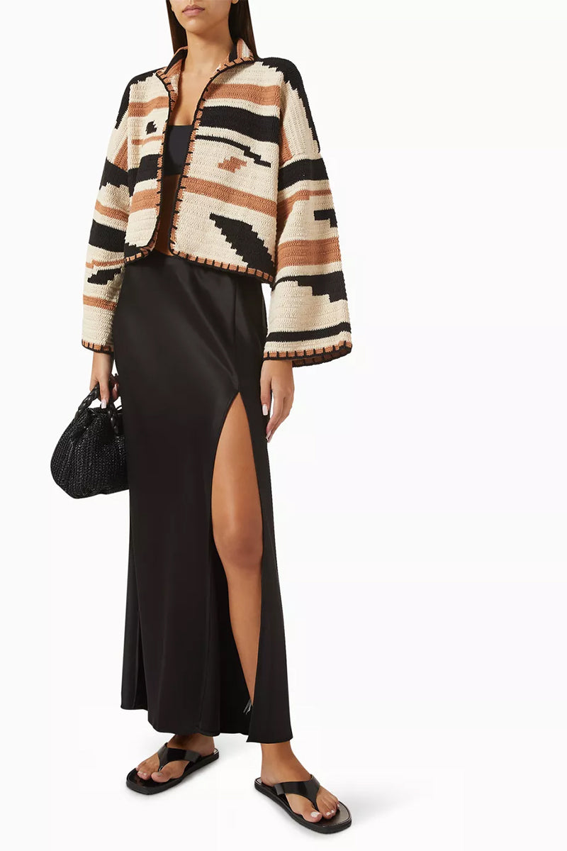 Jessica K Kiona cardigan in camel and black, featuring a cozy knit design, displayed on a hanger.