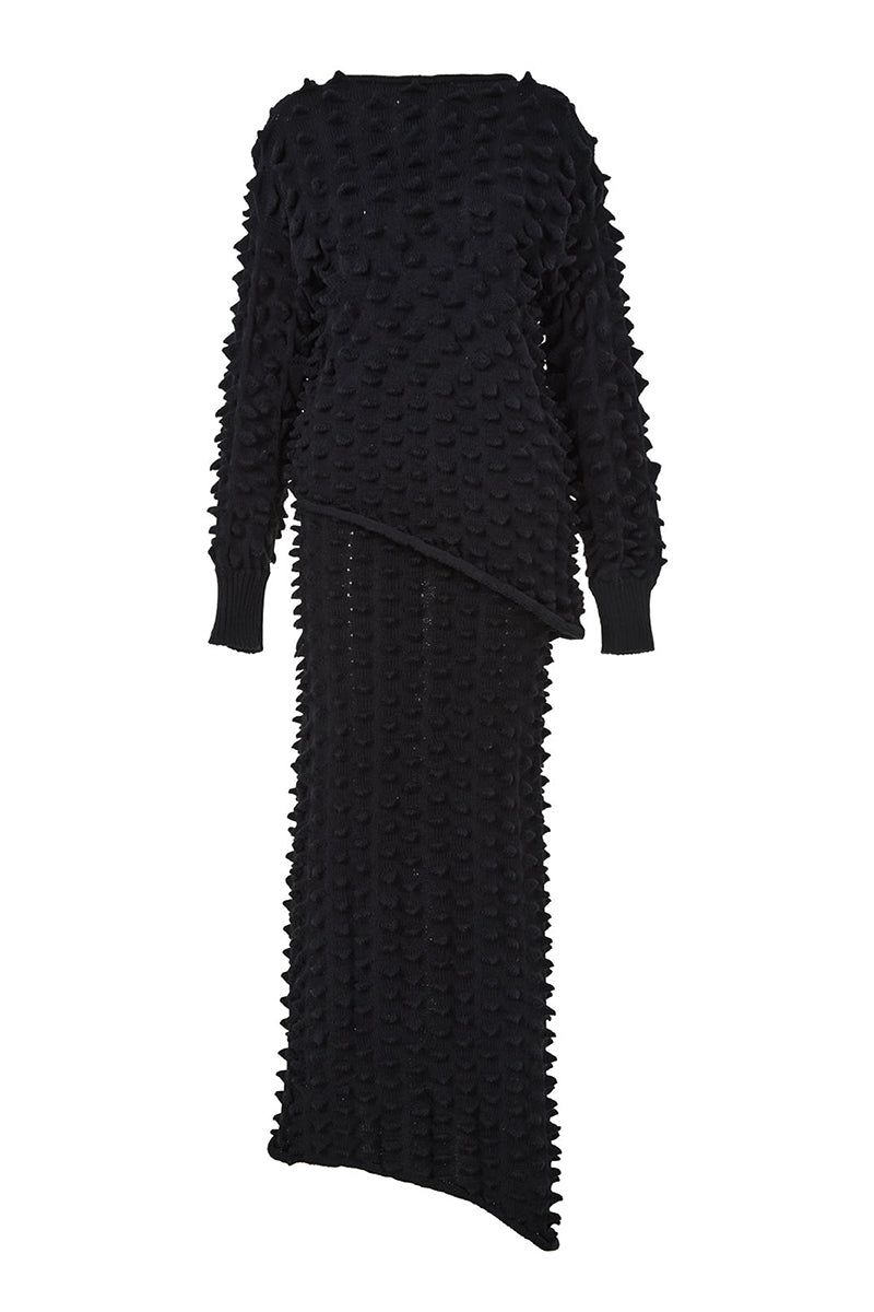 Black knitted co-ord set featuring a sweater and skirt by MAZ Manuela Álvarez, styled together in a coordinated ensemble.