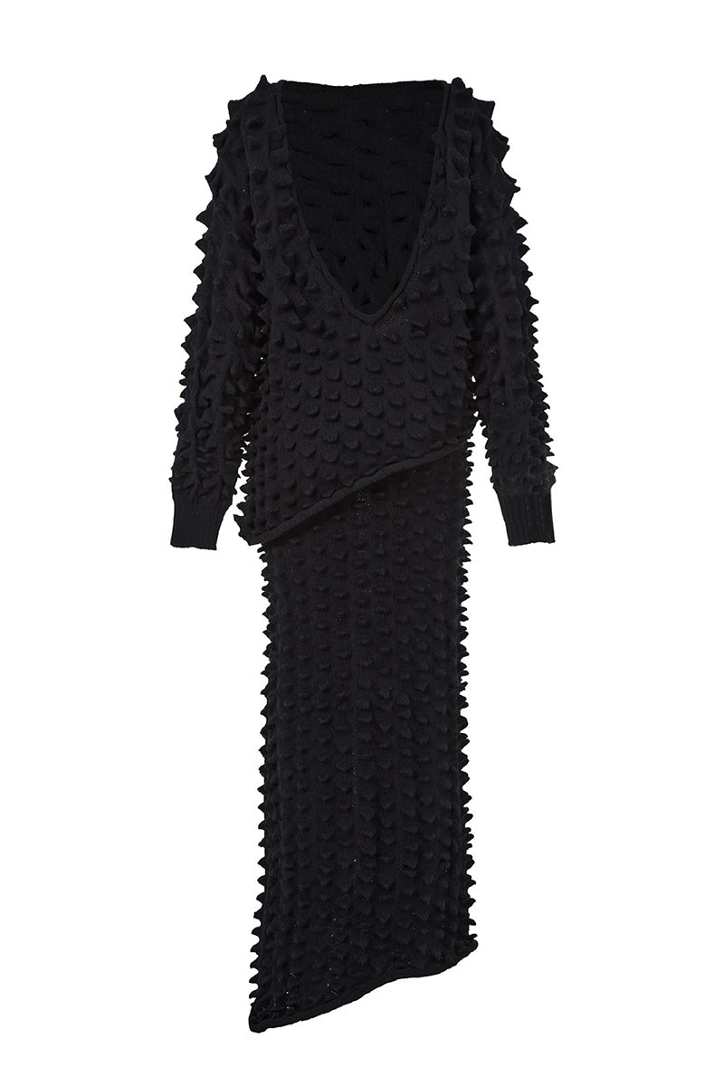 Black knitted co-ord set by MAZ Manuela Álvarez featuring a fitted sweater and matching skirt.
