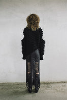 Knitted Peaks sweater by MAZ Manuela Álvarez featuring a cozy, textured knit design in neutral tones.