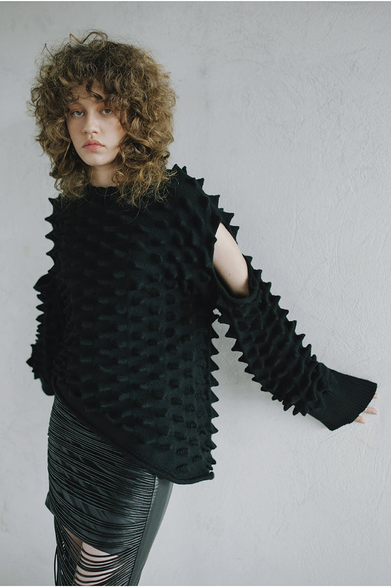 Cozy knitted peaks sweater by MAZ Manuela Álvarez featuring a textured pattern and classic fit, displayed on a neutral background.