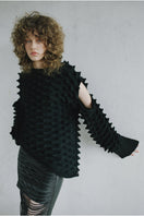 Close-up of a cozy knitted Peaks sweater by MAZ Manuela Álvarez, featuring textured patterns in earthy tones.