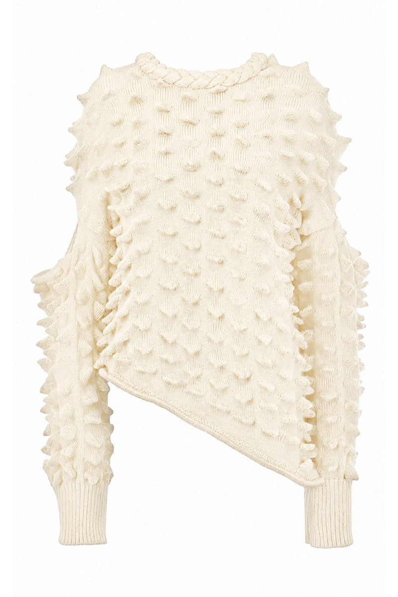 Knitted Peaks sweater by MAZ Manuela Álvarez featuring a cozy, textured knit in neutral tones, displayed on a hanger.