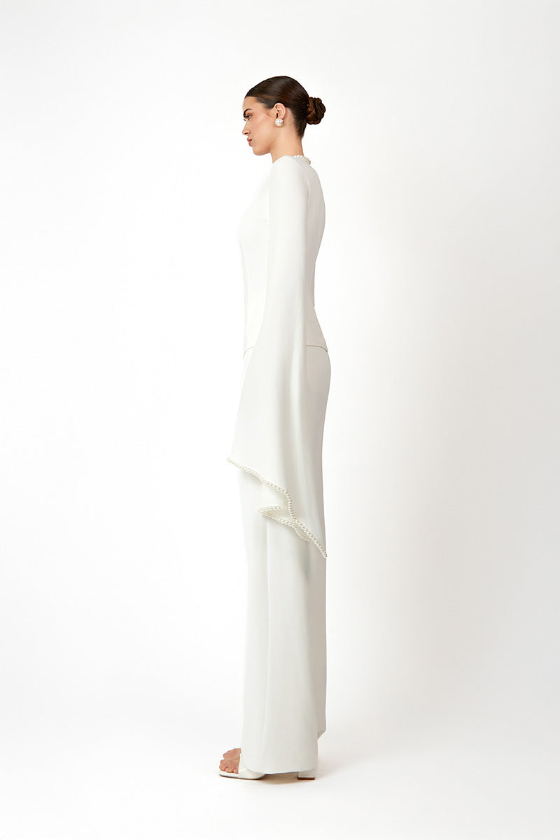 White KADELA top by Khanum's, featuring stylish fabric and a modern design, shown on a model.
