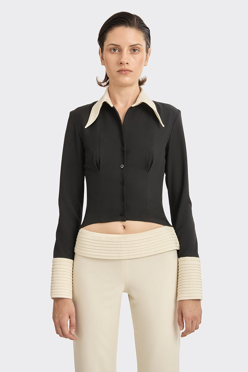 Black Kaia shirt by Stolen Stores featuring a stylish top with white accents, displayed on a hanger against a plain background.