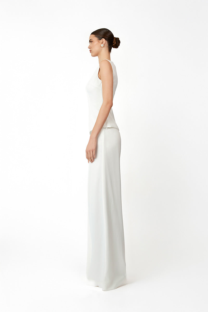 White KASTRID top by Khanum's, featuring a stylish design, shown on a model with detailed fabric and neckline visible.