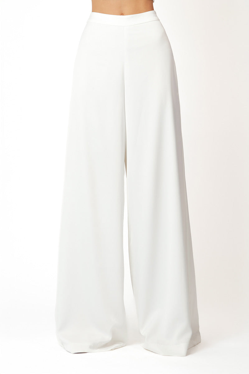 White KASTRID Pants by Khanum's featuring a relaxed fit and sleek design, shown on a model in the product image.