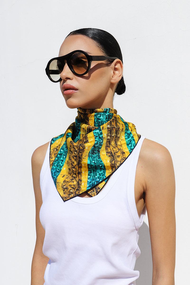 Amel Batita Khamon Brocot silk scarf draped around neck, showcasing intricate patterns and vibrant colors.