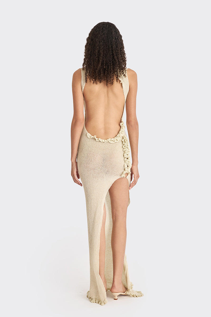 Beige knit low-back maxi dress by Stolen Stores, featuring a flowing silhouette and stylish slip design.