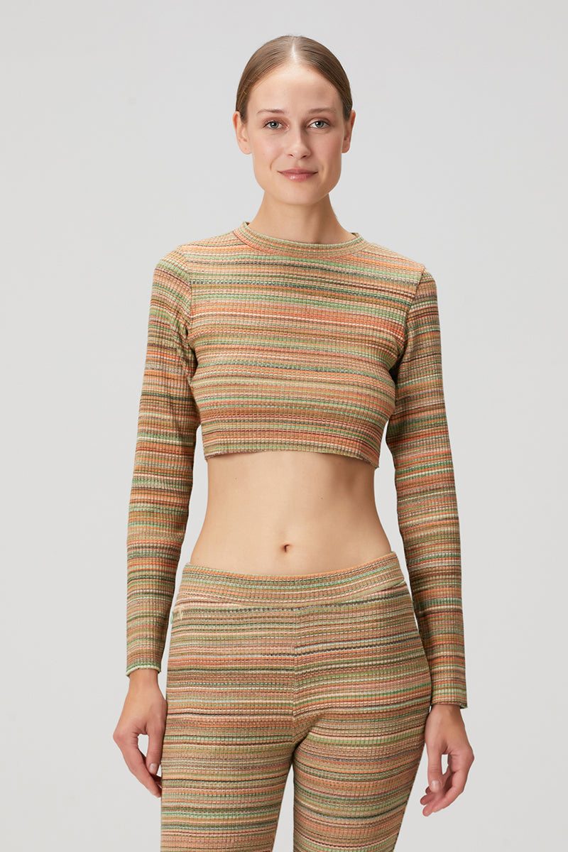 Striped knit crop top by Bassigue featuring a fitted design and long sleeves, styled with casual fashion.