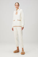 White knit sweater with pocket detail by Bassigue, featuring a cozy, textured design and a stylish, casual fit.