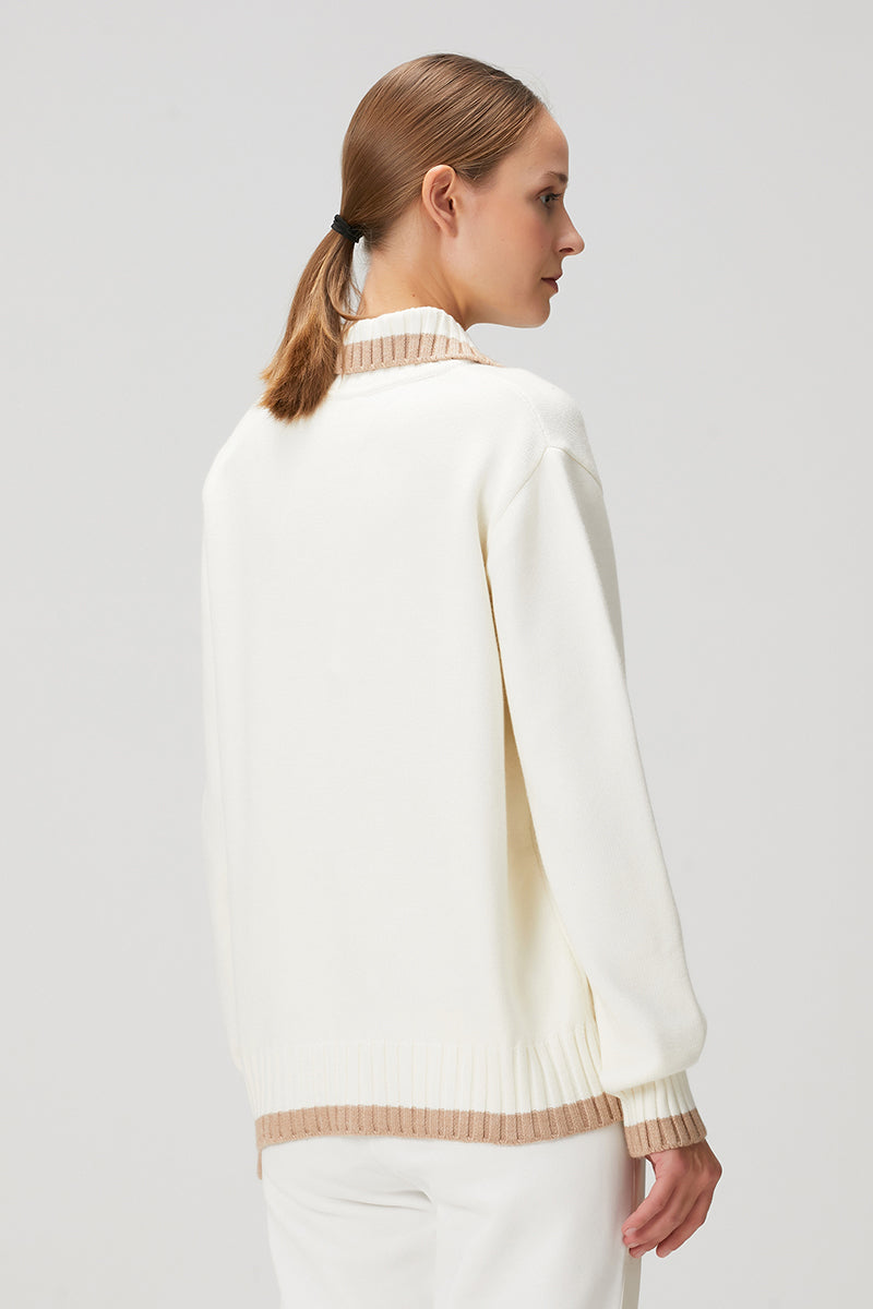 White knit sweater with pocket detailing by Bassigue, featuring a cozy, textured fabric and casual fit.