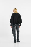 Black knitted sweater with long braids from MAZ Manuela Álvarez, featuring a cozy, textured design and a stylish, casual fit.