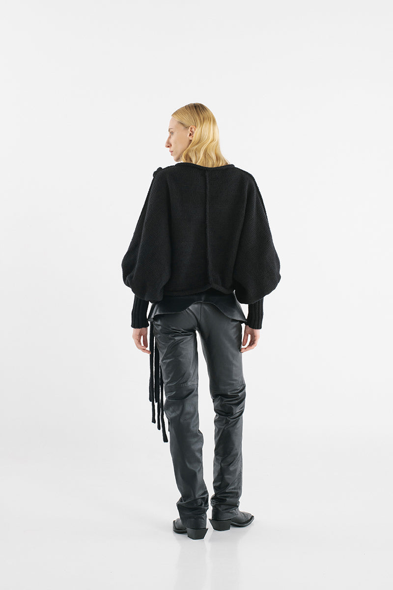 Black knitted sweater with long braids from MAZ Manuela Álvarez, featuring a cozy, textured design and a stylish, casual fit.
