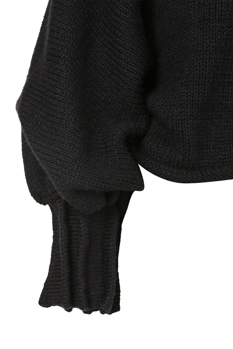 Black knitted sweater with long braids from MAZ Manuela Álvarez, featuring intricate knit pattern and cozy long sleeves.