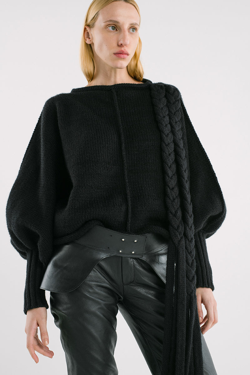 Black knitted sweater with long braid details from MAZ Manuela Álvarez, showcasing cozy, stylish knitwear for casual wear.