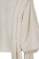 Ivory knitted sweater with long braids by MAZ Manuela Álvarez, featuring cozy, textured knit and long braided details.