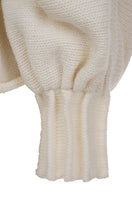 Ivory knitted sweater with long braids by MAZ Manuela Álvarez, showcasing soft, cozy knitwear with detailed braided design.