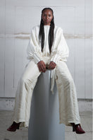 Ivory knitted sweater with long braided details by MAZ Manuela Álvarez, featuring a cozy, textured design for casual wear.