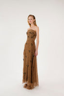 Sepia-toned Kosala embellished strapless maxi dress by Mastani, featuring intricate details and flowing fabric.