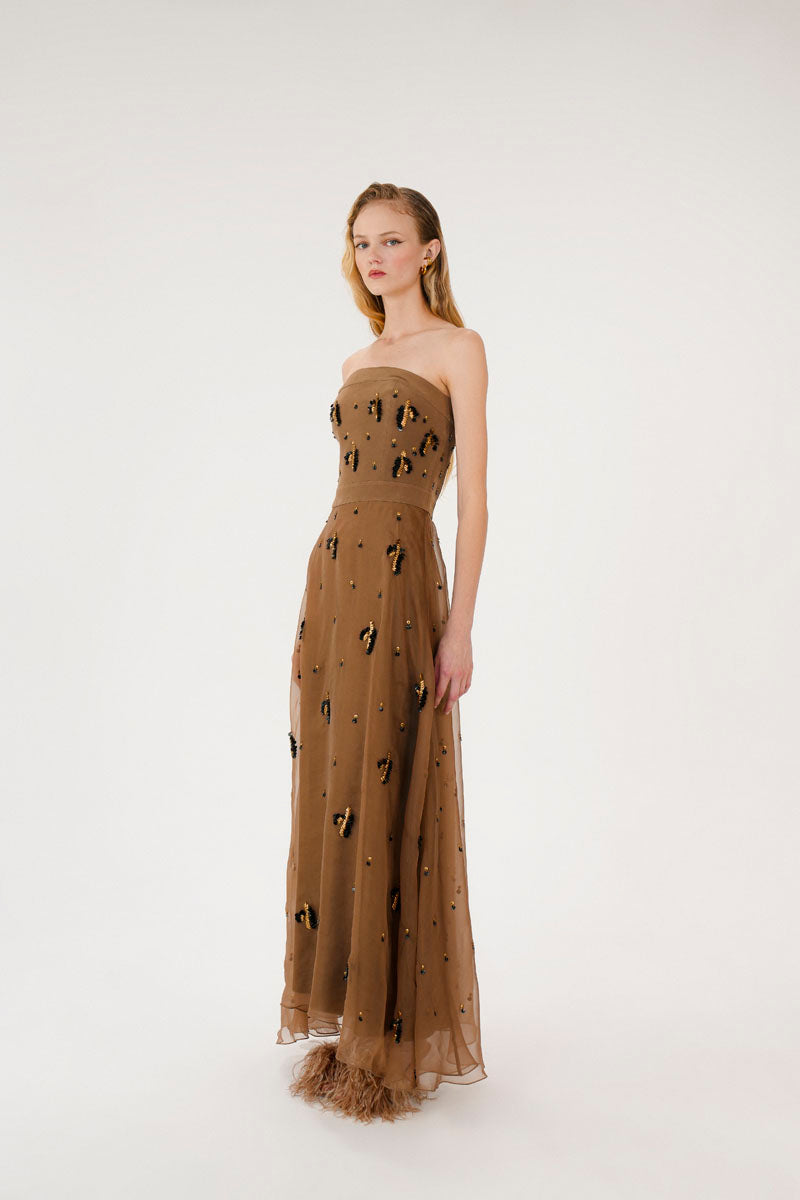 Sepia-toned Kosala embellished strapless maxi dress by Mastani, featuring intricate details and flowing fabric.