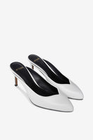 White Lana heels by 10th Floor featuring sleek straps and a pointed toe, stylish footwear for elegant occasions.