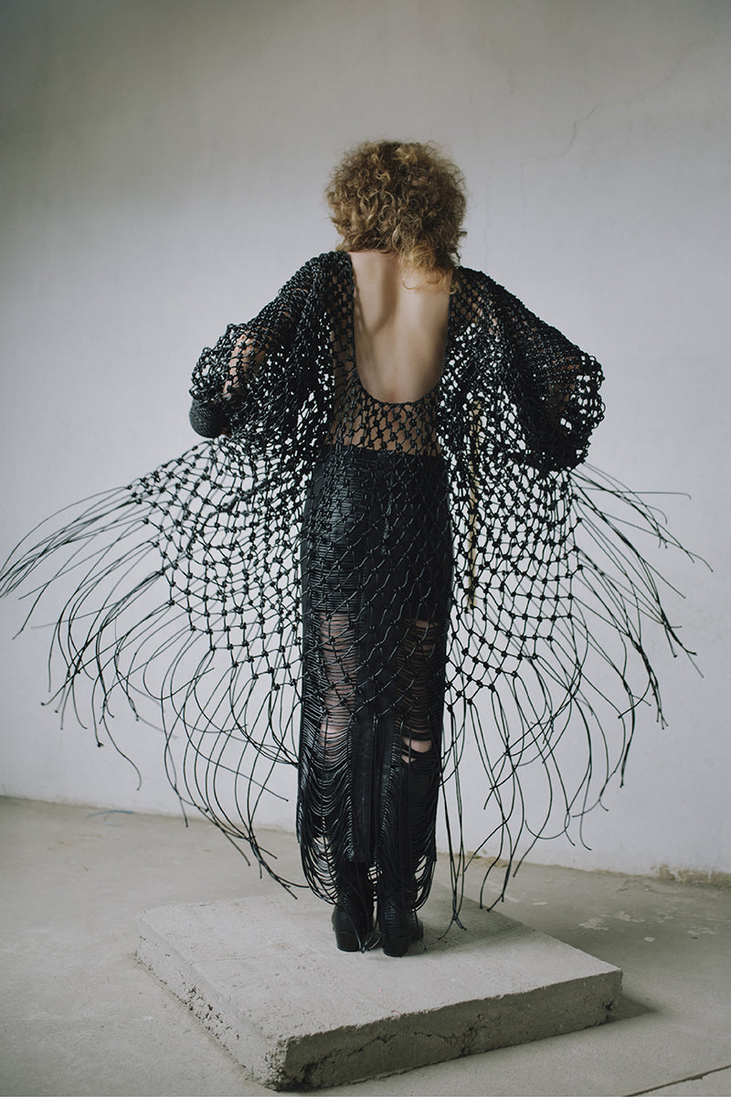 Black leather snake-like cord maxi skirt by MAZ Manuela Álvarez featuring a long flowing design and unique textured pattern.