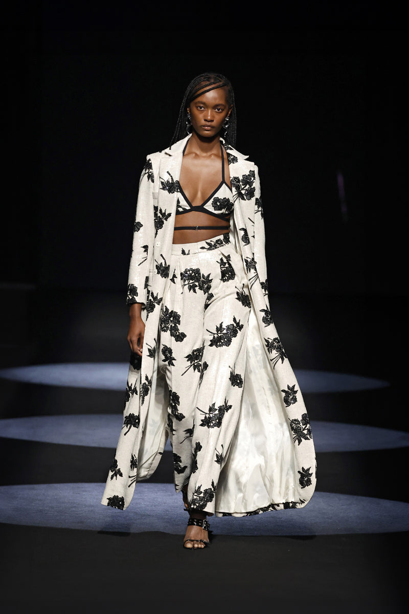 White linen long coat with sequins by JC Pajares, showcasing elegant fabric and sparkling embellishments.