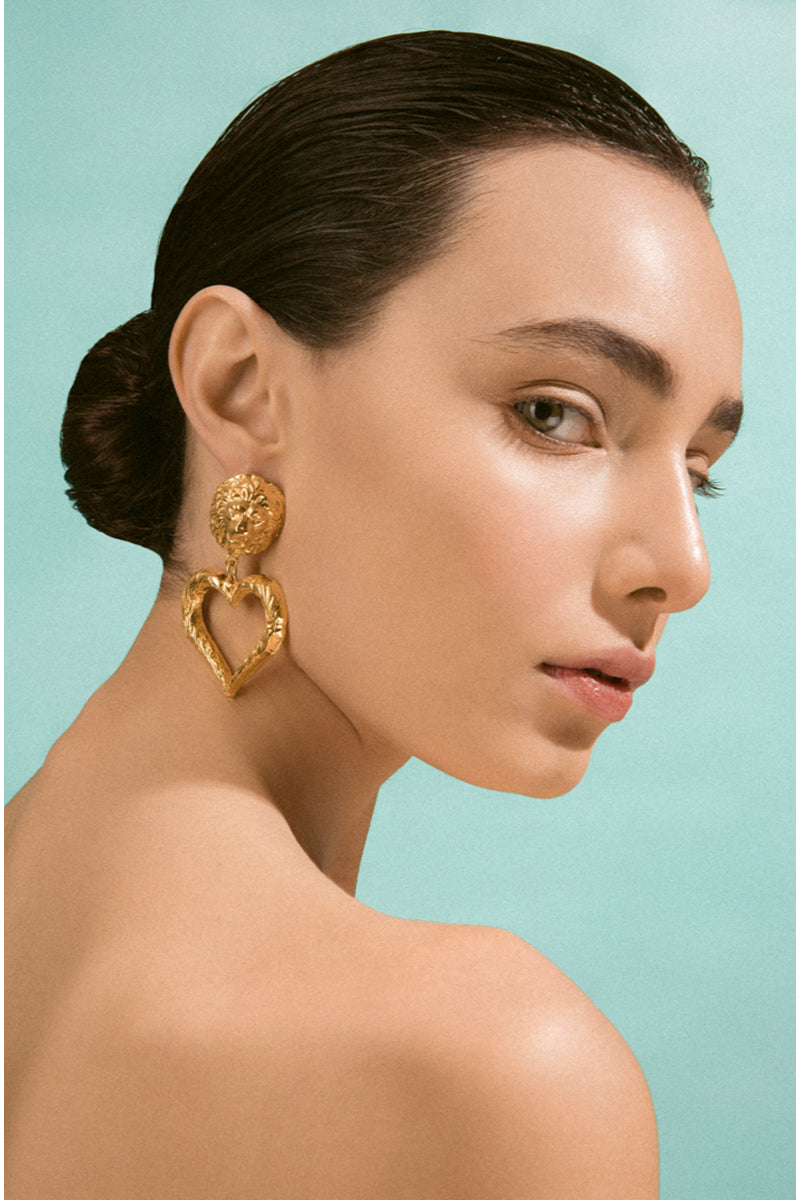 Natia x Lako lion with heart earrings featuring gold-tone lion head and heart charms, fashionable jewelry for women.